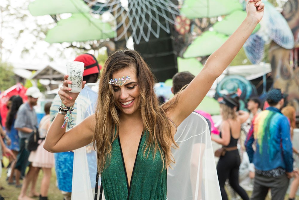 chica con un vestido verde bailando y detrás gente